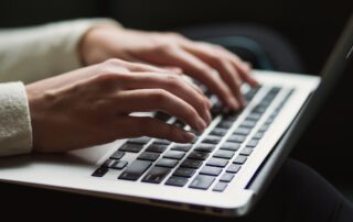 Hände an einem Laptop. Symbolbild für Einträge im deutschen Transparenzregister für Unternehmen. Foto: Kaitlyn Baker auf unsplash.com